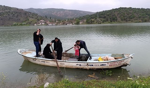 Yolu sular altında kaln köye kayıkla ulaştılar