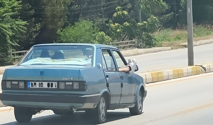 Ayaklarını camdan dışarı çıkartan yolcu trafiği riske attı